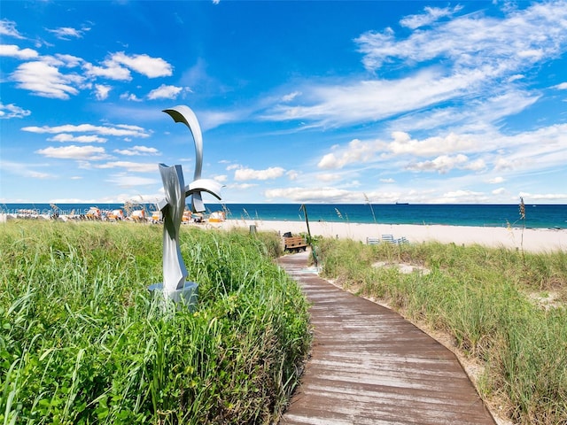 view of property's community with a water view and a view of the beach