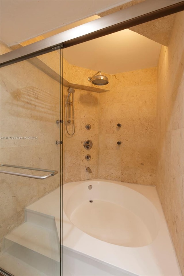 bathroom with shower / bath combination with glass door