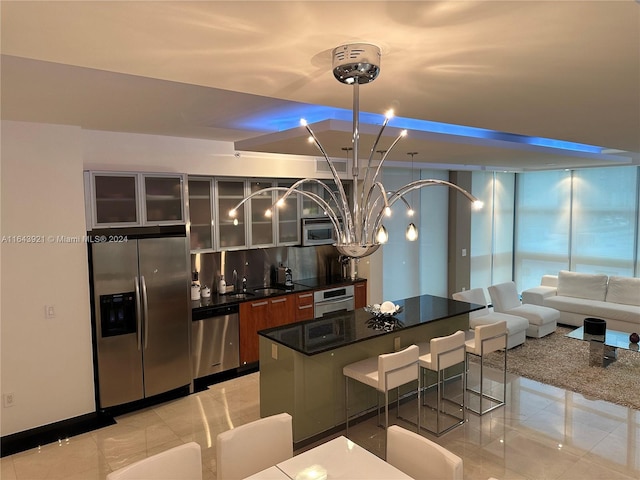 kitchen with a notable chandelier, decorative backsplash, appliances with stainless steel finishes, and sink