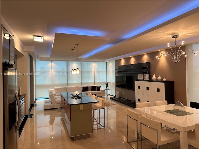 kitchen with white cabinets, a kitchen breakfast bar, hanging light fixtures, and a kitchen island