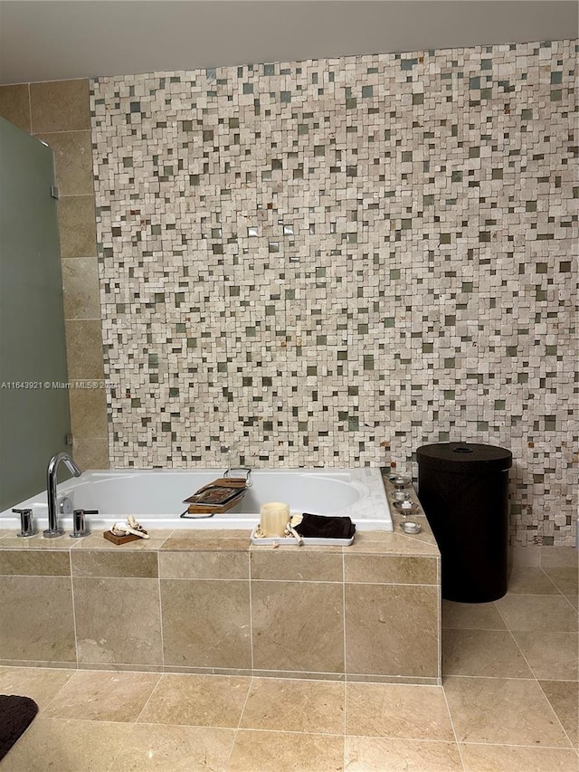 bathroom featuring a relaxing tiled tub and tile walls