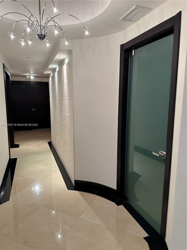 hallway with an inviting chandelier