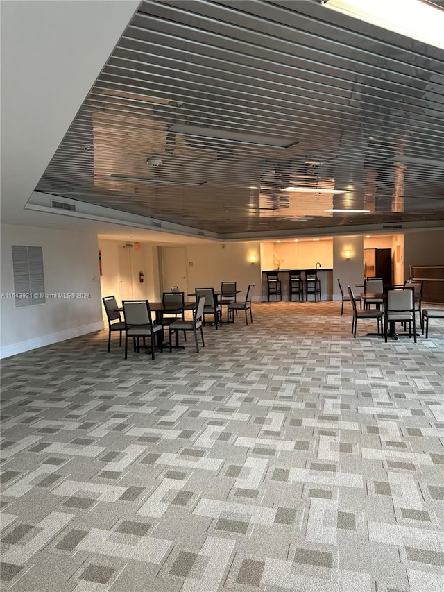 miscellaneous room featuring carpet and a tray ceiling