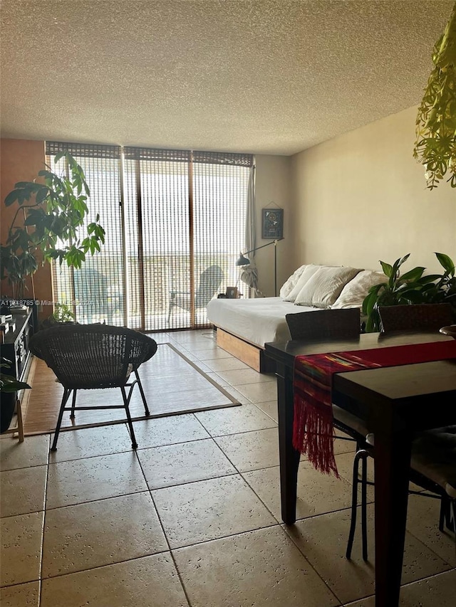 living room featuring a textured ceiling, floor to ceiling windows, and light tile patterned floors