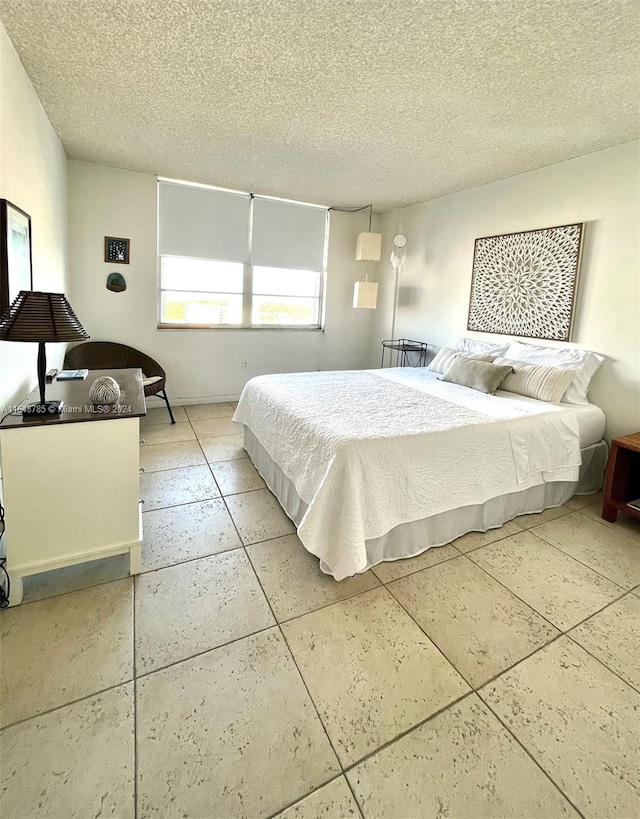 bedroom featuring a textured ceiling and light tile patterned floors