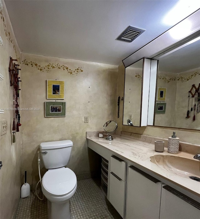 bathroom featuring toilet, tile patterned flooring, and vanity