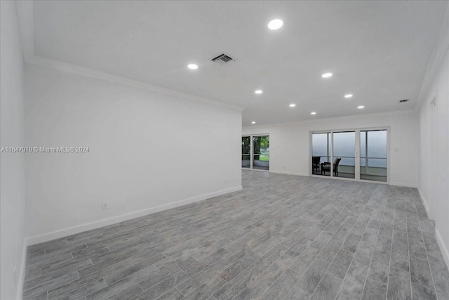 unfurnished room featuring crown molding and light wood-type flooring