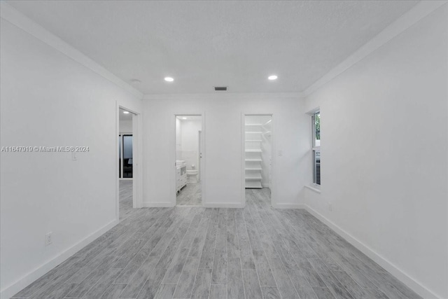 unfurnished room featuring ornamental molding and light hardwood / wood-style floors