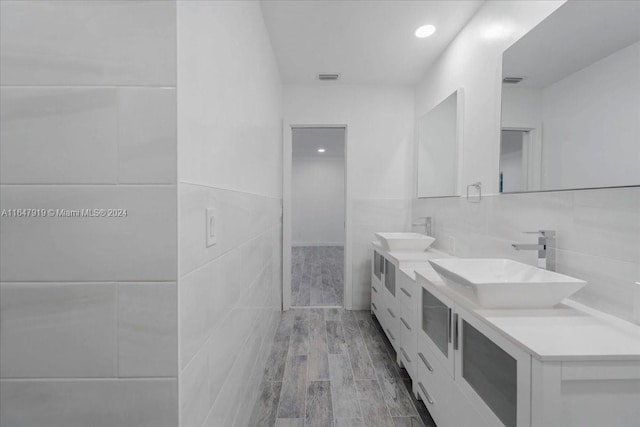 bathroom with vanity, hardwood / wood-style flooring, and tile walls