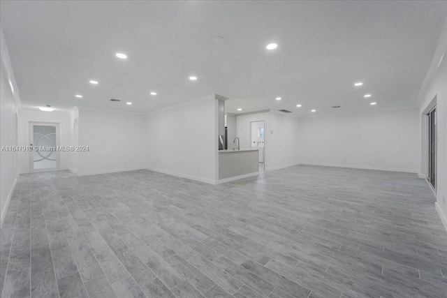 unfurnished living room with light hardwood / wood-style floors and sink