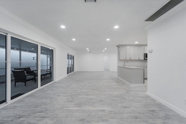 unfurnished living room featuring light hardwood / wood-style floors and sink