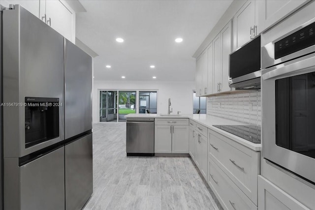 150 SE 3rd Ave, Dania Beach, FL 33004 - kitchen featuring appliances with stainless steel finishes, recessed lighting, tasteful backsplash, light countertops, and white cabinets