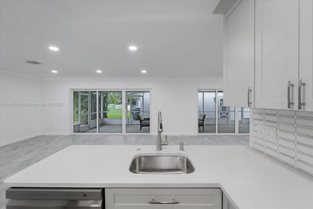 kitchen featuring ornamental molding, sink, white cabinetry, and dishwasher