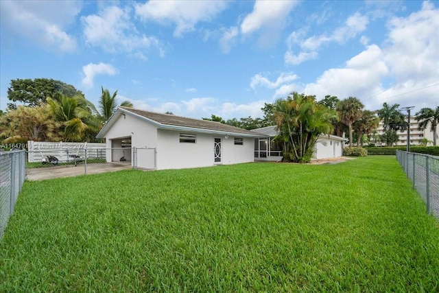 back of house featuring a garage and a lawn