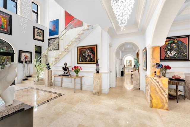 foyer featuring light tile patterned flooring, crown molding, and a healthy amount of sunlight