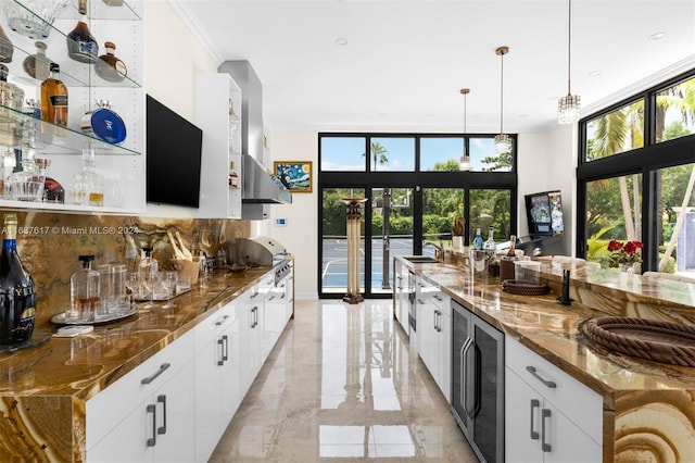 kitchen with decorative light fixtures, stone counters, white cabinets, light tile patterned floors, and floor to ceiling windows