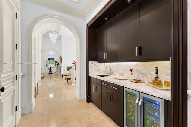 bar featuring sink, dark brown cabinetry, light stone counters, tasteful backsplash, and crown molding