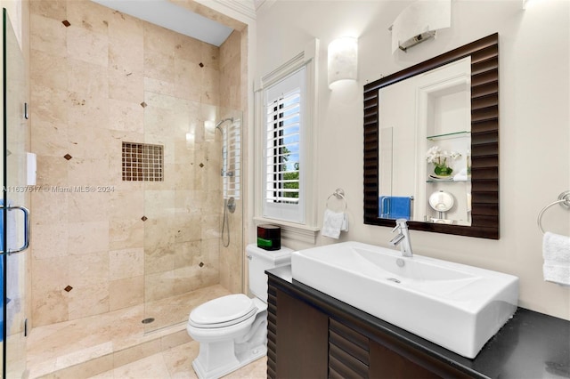 bathroom with tile patterned floors, a shower with shower door, vanity, and toilet