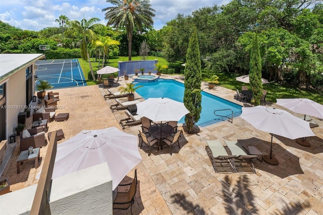 view of pool with a patio and an in ground hot tub