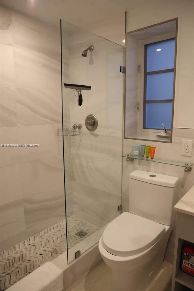 bathroom with toilet, tiled shower, and tile walls