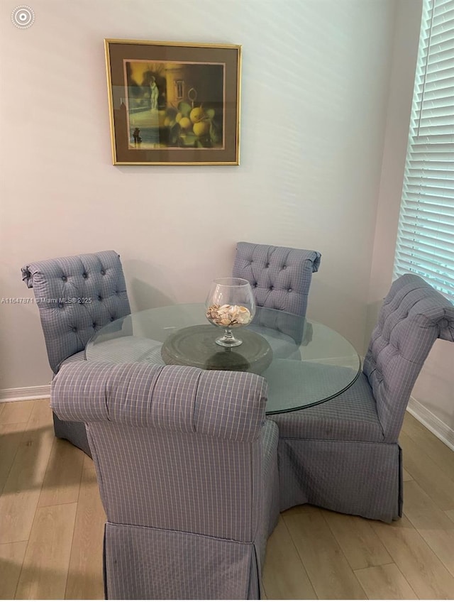 dining space featuring baseboards and wood finished floors