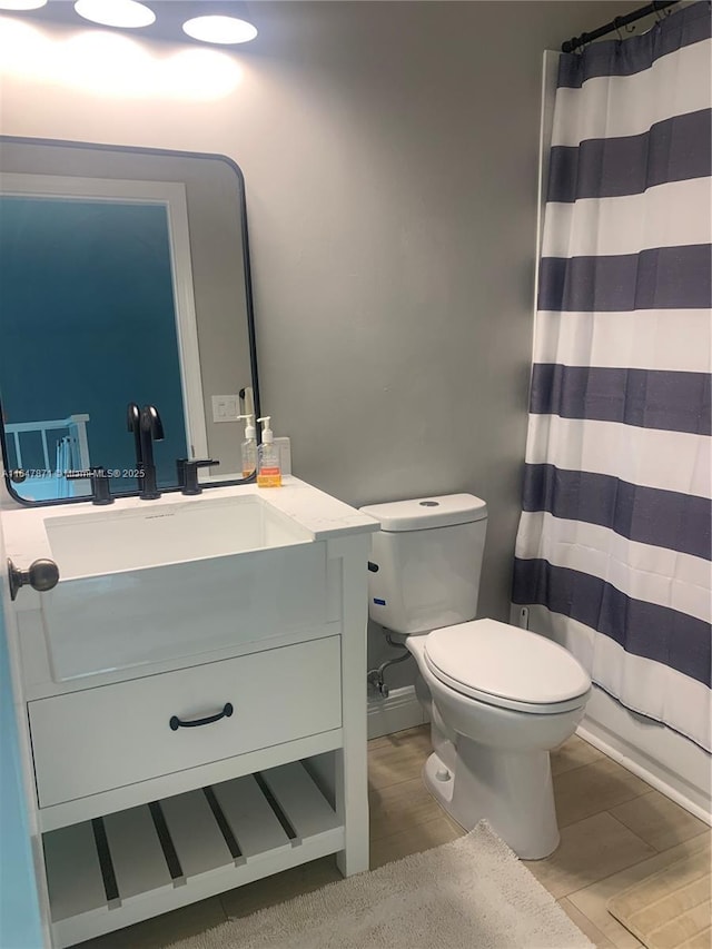 bathroom featuring a shower with curtain, vanity, and toilet