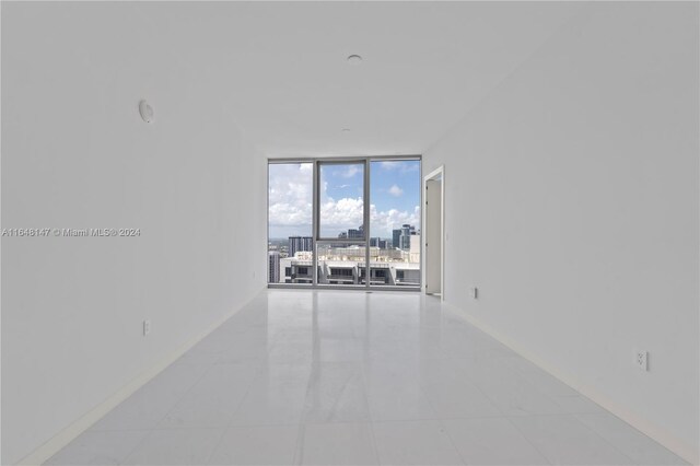 300 Biscayne Blvd Way Unit 4604, Miami, FL 33131 - spare room featuring a wall of windows, baseboards, and light tile patterned flooring