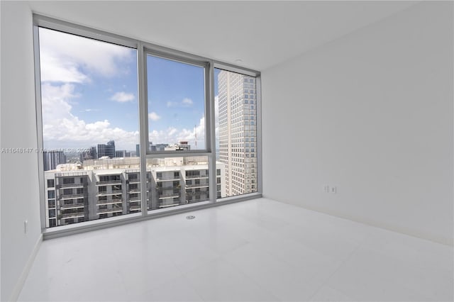 unfurnished room featuring a wall of windows