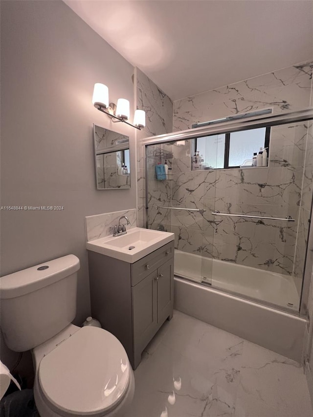 full bathroom featuring vanity, toilet, and combined bath / shower with glass door