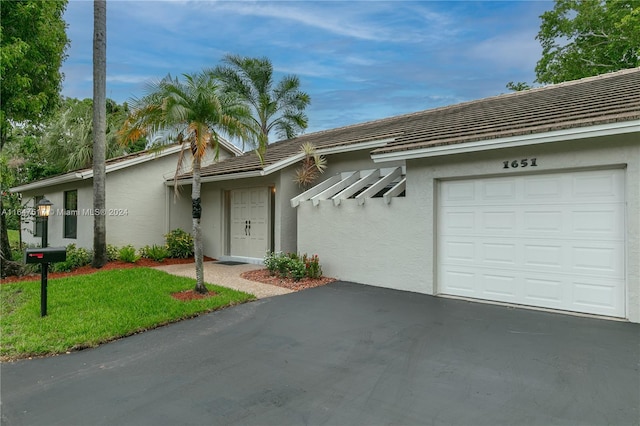 ranch-style home featuring a garage and a front yard