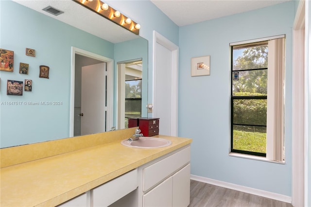 bathroom with a textured ceiling, hardwood / wood-style flooring, and vanity