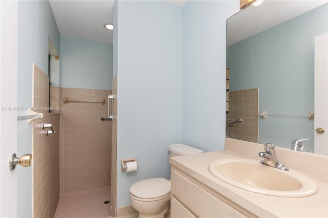 bathroom featuring tiled shower, toilet, and vanity