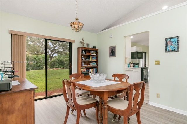 dining space with light hardwood / wood-style flooring and vaulted ceiling