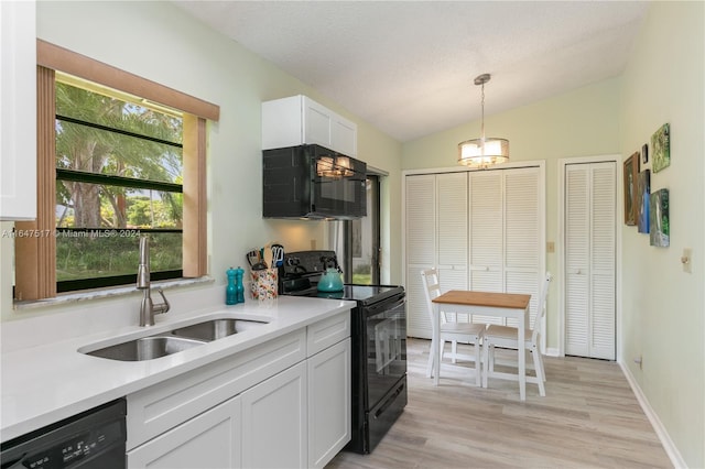 kitchen with light hardwood / wood-style floors, vaulted ceiling, white cabinetry, hanging light fixtures, and black appliances