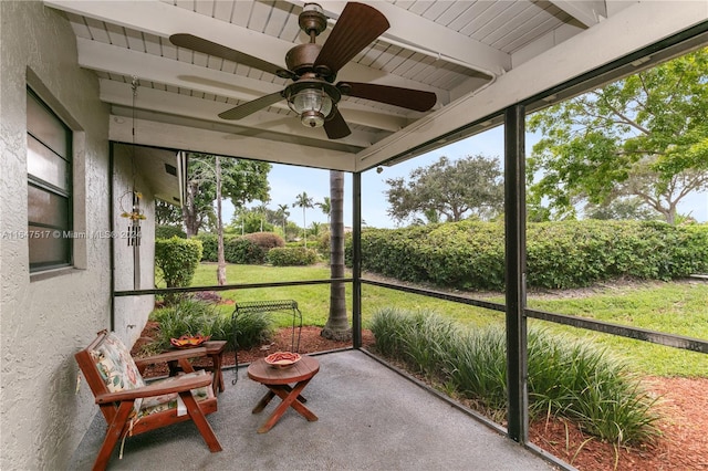 sunroom with beam ceiling and ceiling fan