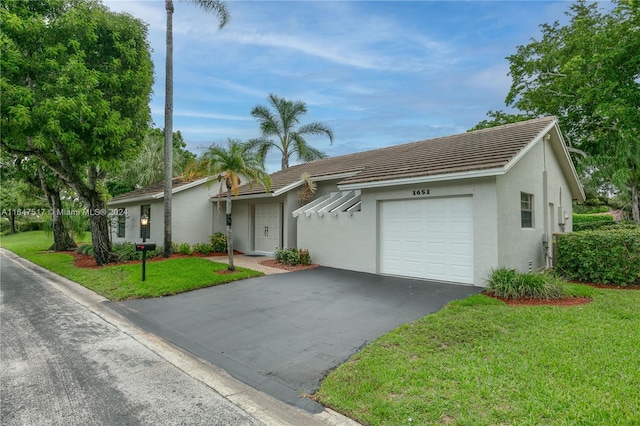 ranch-style house featuring a front yard and a garage