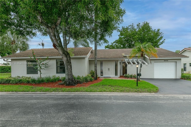 ranch-style home with a front lawn and a garage