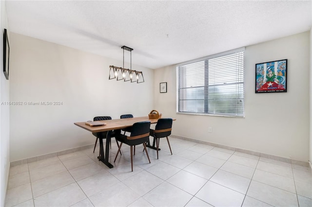 tiled dining area featuring a textured ceiling