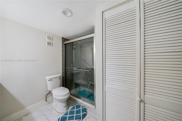 bathroom featuring tile patterned flooring, toilet, and walk in shower