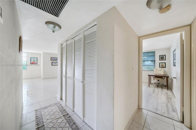 corridor featuring light tile patterned flooring and a healthy amount of sunlight