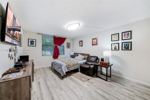 bedroom featuring a textured ceiling and light hardwood / wood-style flooring