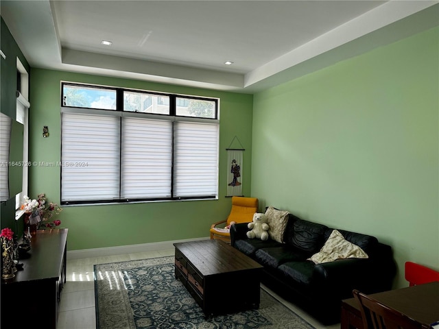 tiled living room featuring a tray ceiling