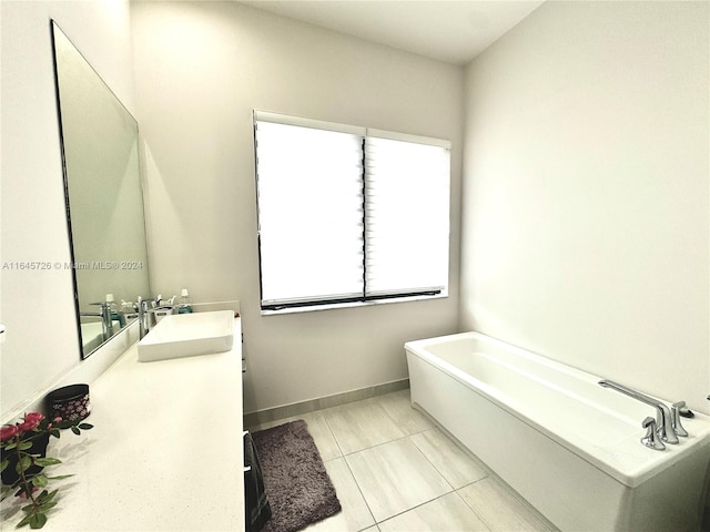 bathroom featuring a tub to relax in, vanity, and tile patterned floors