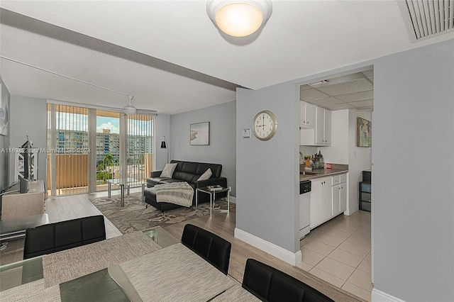 tiled dining space with sink and a wall of windows