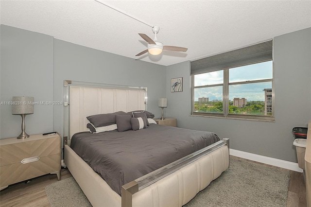 bedroom featuring a textured ceiling, light hardwood / wood-style flooring, and ceiling fan