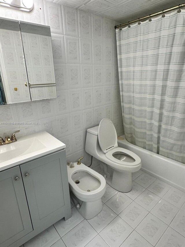 full bathroom with a bidet, vanity, tile patterned flooring, shower / tub combo, and toilet