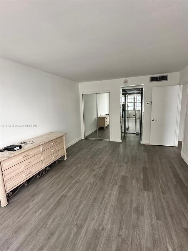 unfurnished living room with dark wood-type flooring