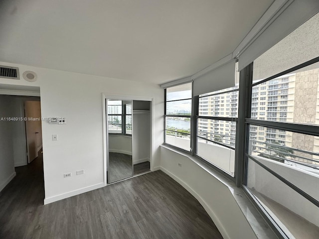 unfurnished bedroom with a closet and dark hardwood / wood-style floors