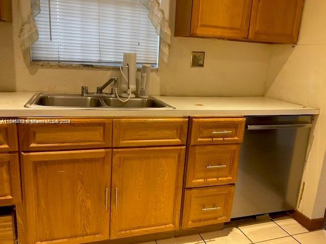 kitchen featuring light tile patterned floors, sink, and dishwasher