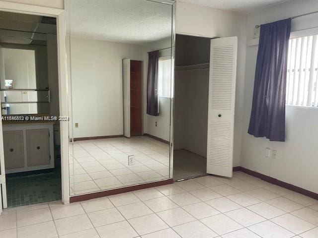 unfurnished bedroom featuring a closet and light tile patterned floors